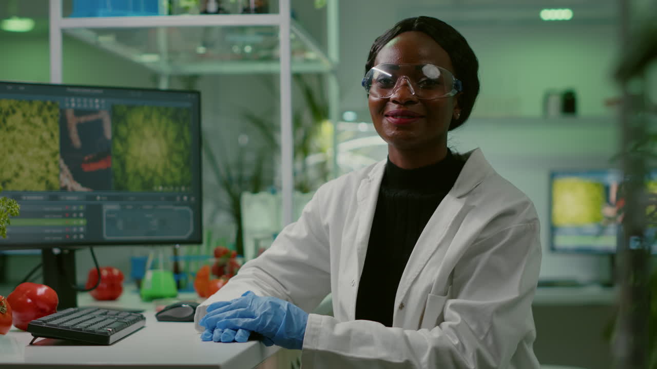 Portrait of african biologist in white coat looking into camera