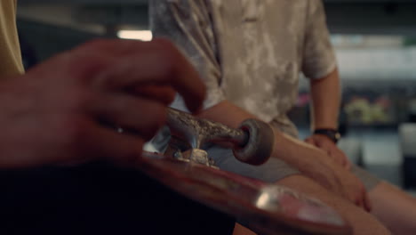 Man-hands-touching-skateboard-wheels-at-skate-park.-Spinning-skate-board-wheel.