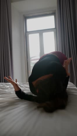Woman stretching and dancing in a bedroom