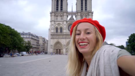 4k young woman taking selfie in paris at city notre dame using mobile phone