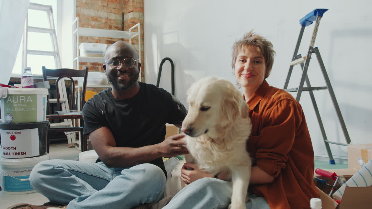 Portrait of Happy Couple with Cute Dog in Living Room during Home Renovation
