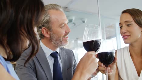 three people clinking glasses