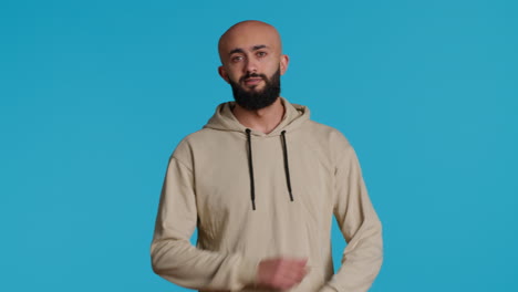 middle eastern serious adult posing on studio backdrop