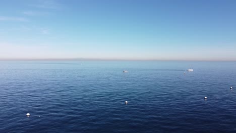 Drone-Retrocede-Desde-El-Océano-Hasta-La-Playa-Descando,-Isla-Catalina,-California