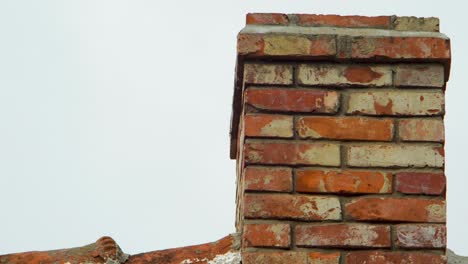 view of old red clay brick chimney in overcast day, medium closeup slow zoom in