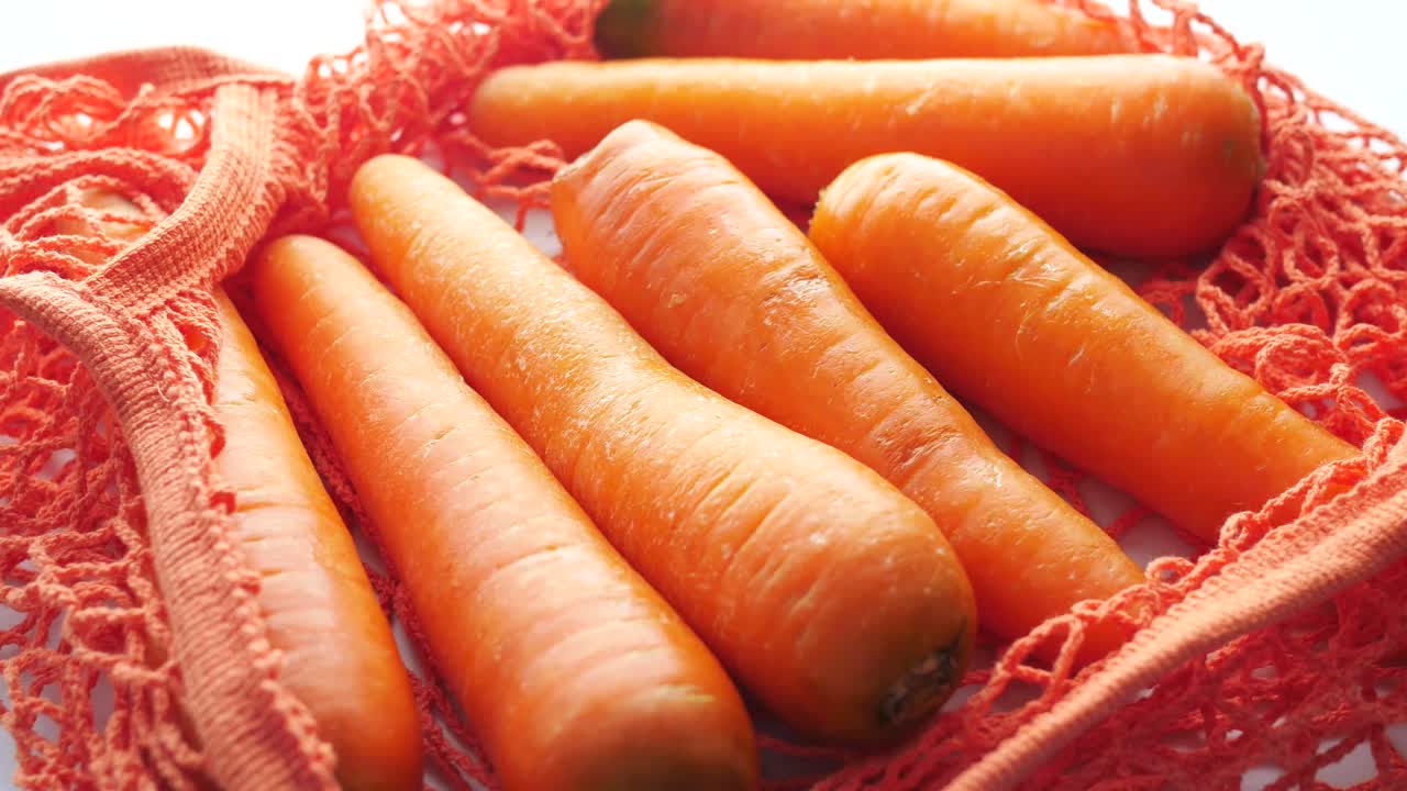 Zanahorias frescas en una bolsa de malla reutilizable