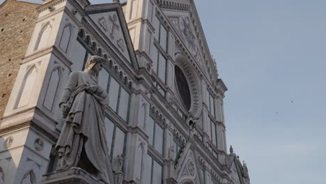 Statue-Von-Dante-Alighieri-Mit-Einem-Lorbeerkranz-Auf-Dem-Kopf-Und-Einem-Adler-An-Seiner-Seite-In-Florenz-Mit-Der-Basilika-Santa-Croce-Im-Hintergrund