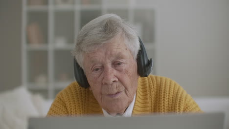 Senior-woman-with-laptop-computer-calling-on-smartphone-at-home.-Old-woman-having-a-video-call-on-the-laptop-smiling-and-talking-happily-indoors-in-a-cozy-apartment.-doctor-video-calling-older-patient