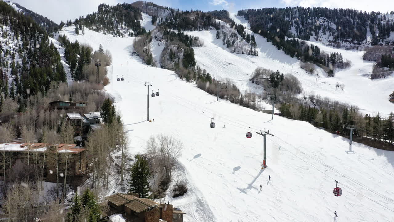 teleférico en la estación de nieve haciendo nevadas mientras la gente esquía cuesta abajo, vista aérea