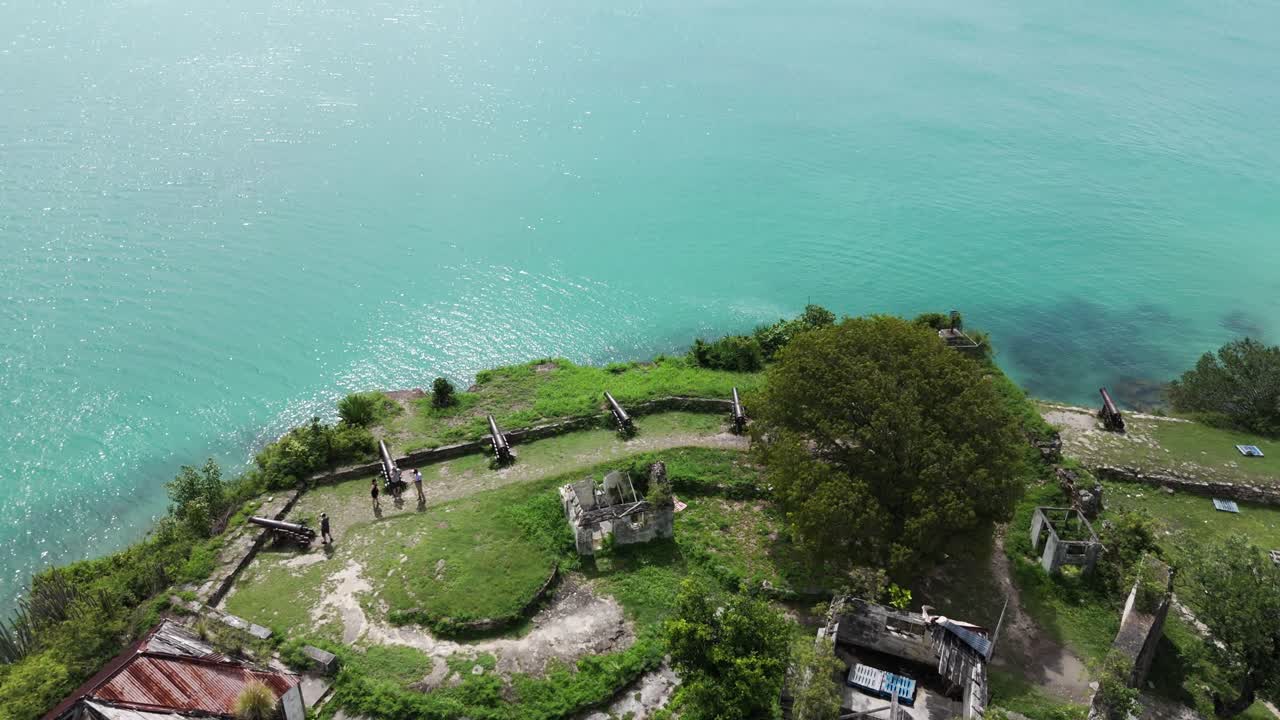 Ruins of Fort James overlook turquoise waters surrounded by lush greenery in Antigua's Caribbean coast