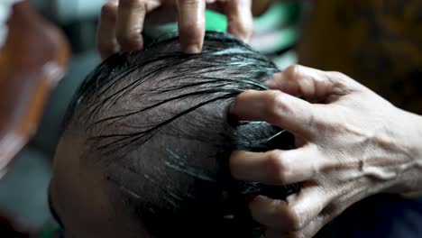 oil being massaged onto head showing signs of hair loss