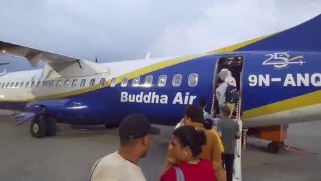 people entering the buddha air plane flying from pokhara to tribhuvan international airport in kathmandu - nepal