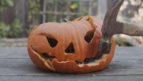 primer plano en cámara lenta de una calabaza podrida que es aplastada con un martillo