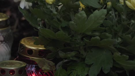 Candle-lights-and-flowers-at-a-cementary-during-night-time