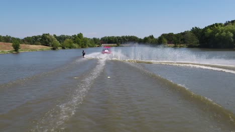 Luftaufnahme-Nach-Einem-Boot-Und-Mann-Wasserski---Zeitlupe,-Drohnenaufnahme