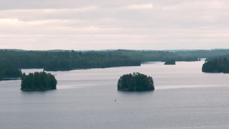 Canoe-Passing-Between-Islands-On-A-Vast-Lake