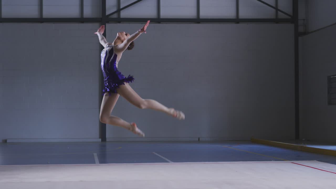 gimnasta adolescente actuando en el salón de deportes