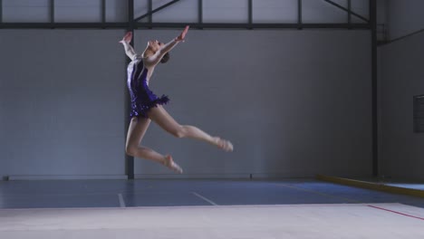 Teenage-female-gymnast-performing-at-sports-hall