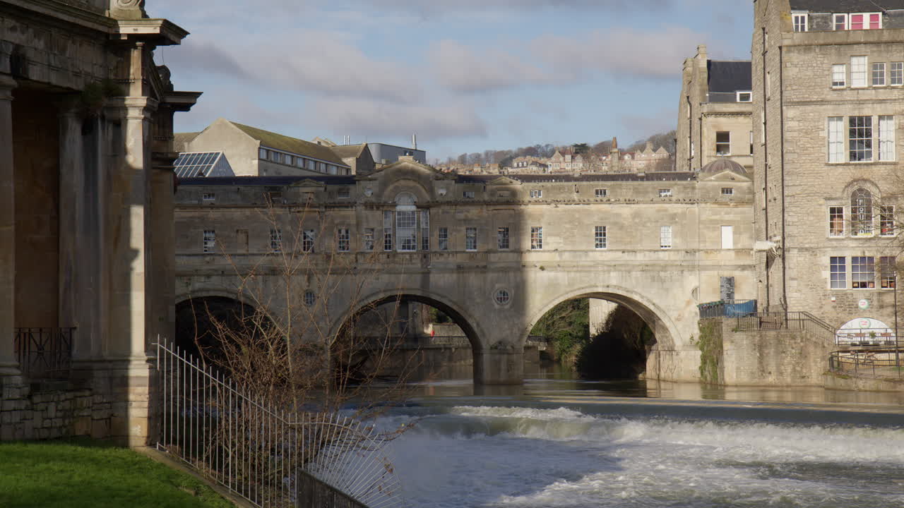 Water From River Avon Flowing Through The Weir Near The Pulteney Bridge In Bath, England