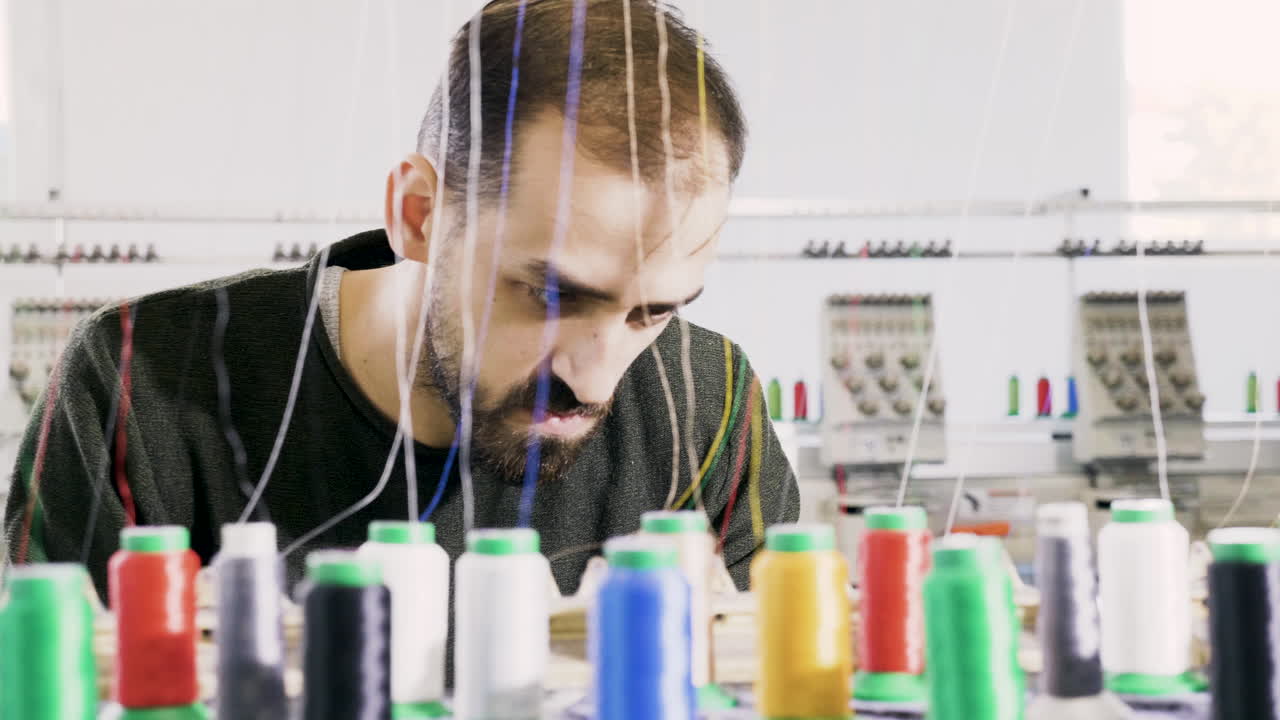 Man in a fabric factory checking the cotton sewing machinery