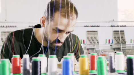 man in a fabric factory checking the cotton sewing machinery