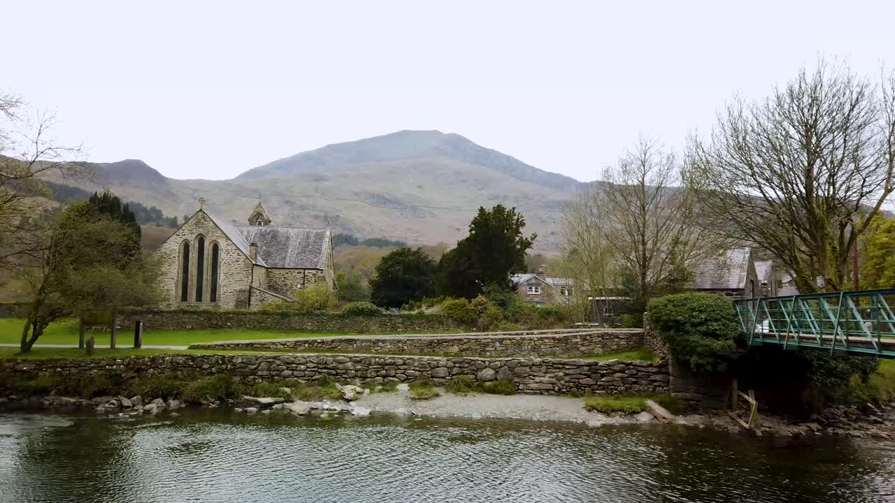 River Glaslyn, Beddgelert, North Wales, UK - showing the mountain Moel Hebog in the background and the Church of St Mary.