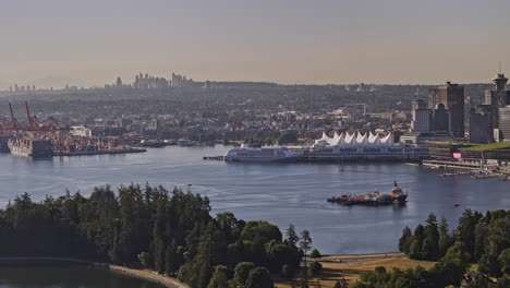 Vancouver-BC-Canada-Aerial-v78-zoomed-drone-flyover-Stanley-Park,-panning-view-capturing-Eastside-shipyard,-Burnaby-and-waterfront-downtown-cityscape---Shot-with-Mavic-3-Pro-Cine---July-2023