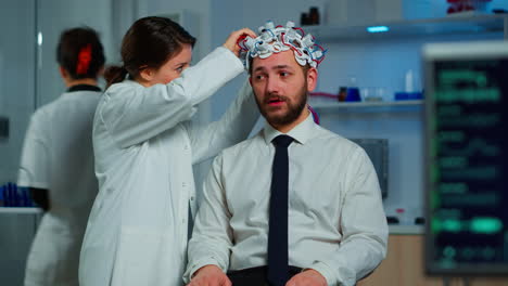 paciente con auriculares de exploración de ondas cerebrales sentado en un laboratorio de estudio cerebral