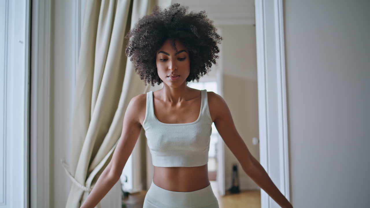 Nahaufnahme einer Yogi-Frau in Namaste-Pose zu Hause. Frau mit lockigem Haar praktiziert Yoga-Asana.