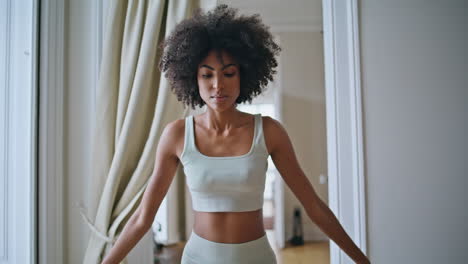 yogi woman namaste pose at home closeup. curly hair lady practicing yoga asana