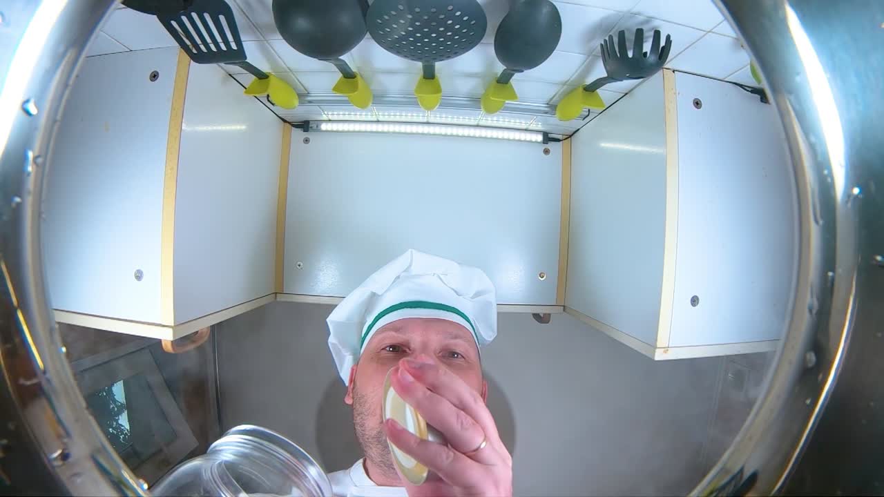 el chef prepara caldo de verduras, el chef añade especias a la sopa, la vista desde la sartén en cámara lenta.