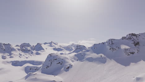 aerial footage of the iconic freeride paradise of verbier on a stunning bluebird day. snow-covered peaks, wide open faces, and legendary off-piste terrain under clear alpine skies