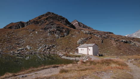 lone house by a lake in the alps mountains in switzerland