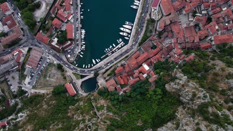 antena cinemática de ojo de pájaro sobre el casco antiguo y el puerto de kotor, montenegro, un destino popular en el mar adriático para los superyates de lujo