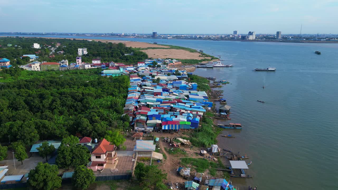 fishing village with colorful shacks along the Mekong river in Cambodia, a developing country in Southeast Asia. Stunning aerial view flight drone shot footage from above