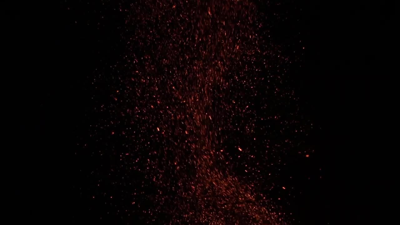una gran fogata escupe muchas chispas en el cielo nocturno