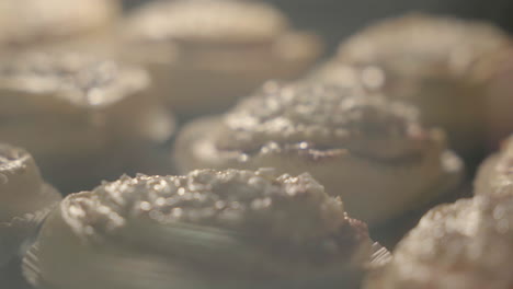 close up of cinnamon buns getting baked in the oven