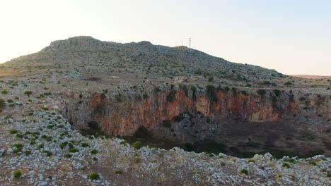 Custonaci-Sicily-Italy-geologic-depression-with-iron-rich-mineral-close-to-the-town-of-San-Vito-Lo-Capo,-Aerial-drone-forward-low-speed-motion