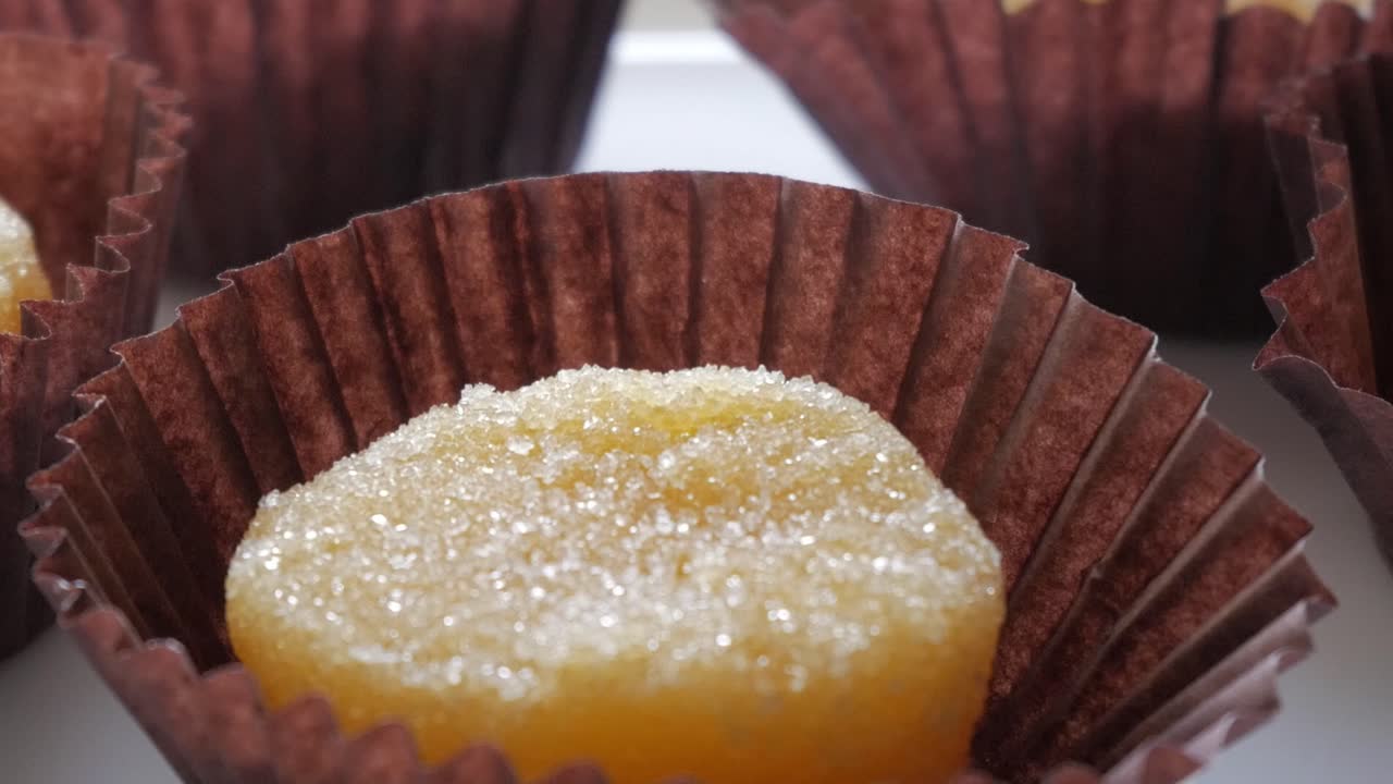 Sugary yellow sweet in brown wrapper, traditional Spanish egg yolk dessert