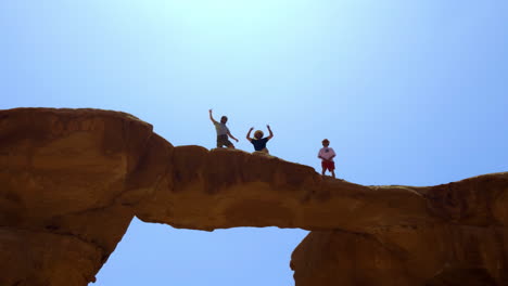 group of friends enjoying the view from a natural rock bridge