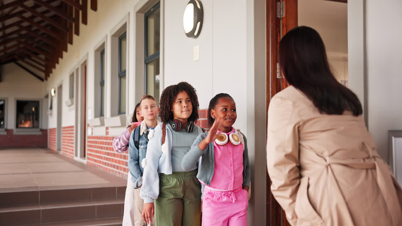 Students entering school with teacher greeting