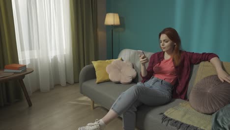 woman relaxing on sofa using smartphone in modern living room