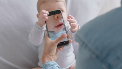 madre tomando una foto de su bebé usando un teléfono inteligente disfrutando de fotografiar a un bebé lindo compartiendo el estilo de vida de la maternidad en las redes sociales