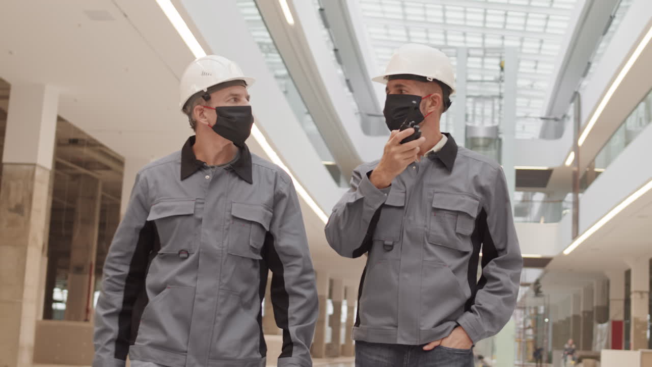 Builders Wearing Masks Walking Around Construction