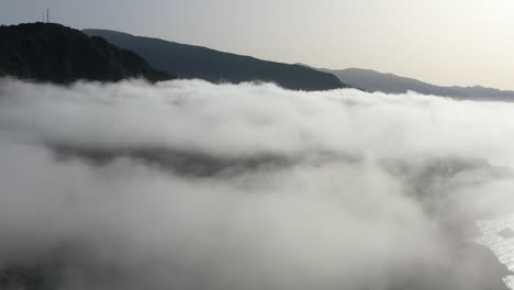 flying above clouds on tropical island coastline, aerial view of madeira island, portugal