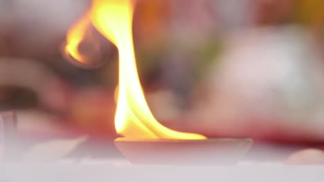 Close-up-of-lit-oil-lamp-during-Indian-wedding-celebration