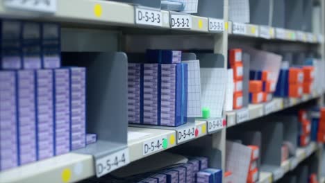 tracking shot of organised warehouse storage shelves with different products