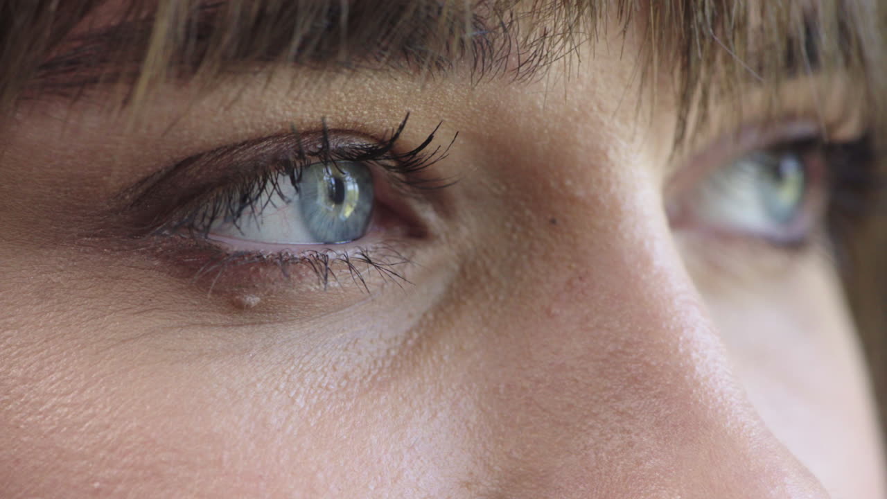 가까운 여자 파란 눈은 메이크업 화장품을 열고 있습니다.