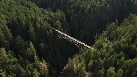 Drone-shot-tilting-over-a-car-driving-on-the-High-Steel-Bridge,-in-Washington,-USA