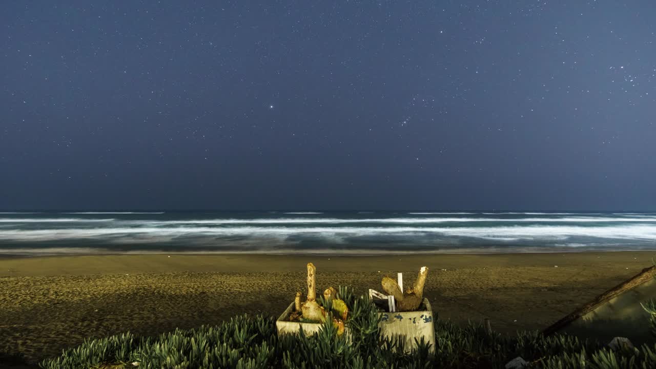 звезды ночью с созвездием ориона движутся над пляжем в средиземноморье, италия